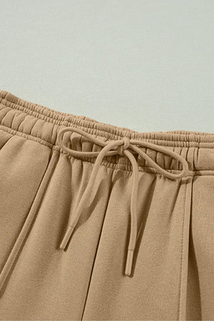 Tan wide-leg sweatpants with drawstring and relaxed seam detail