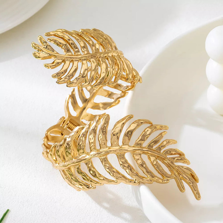 Gold bracelet featuring leaf design and floral