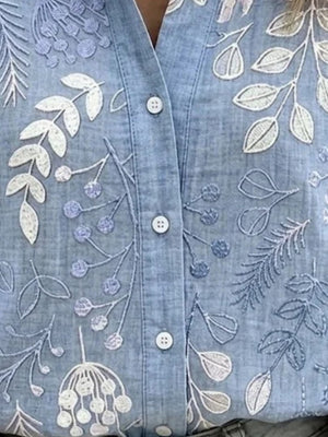 white button-down shirt featuring buttoned and floral
