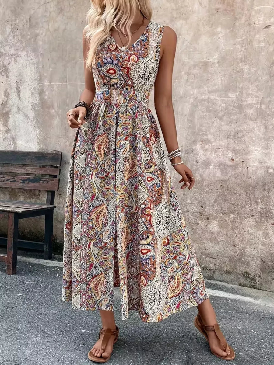 Vibrant paisley print maxi dress with cinched waist and dramatic slit.