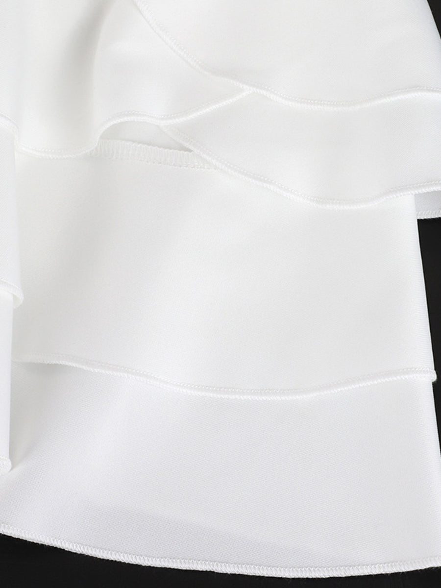 White tiered ruffled mini dress with a fitted bodice and elegant details.