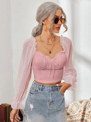 Pink bustier blouse with tie front and sheer ruffled sleeves