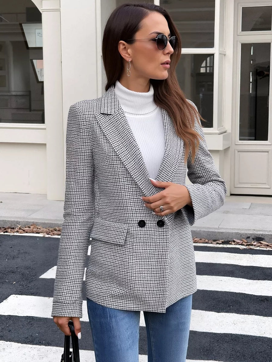 Houndstooth double-breasted blazer with notched lapels and button closure, styled with a white turtleneck and jeans.