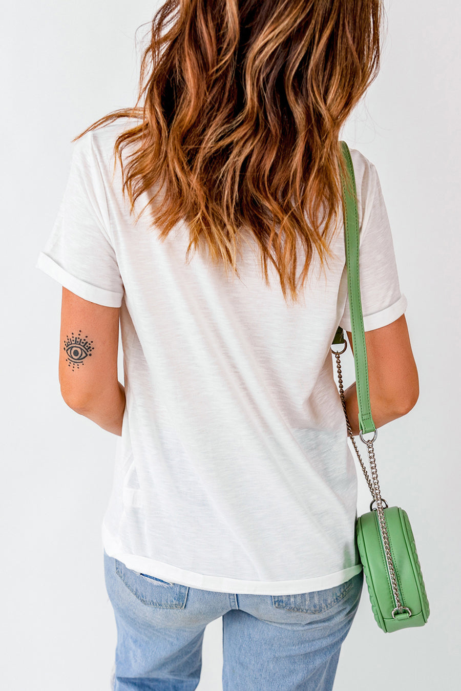 White casual tee with rolled sleeves and a bold graphic detail on the arm.