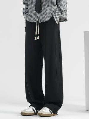 Men's black casual loose-fit drawstring pants with pockets and white drawstrings.