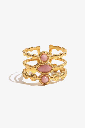 Gold triple stone openwork ring with pink gemstones and textured band.