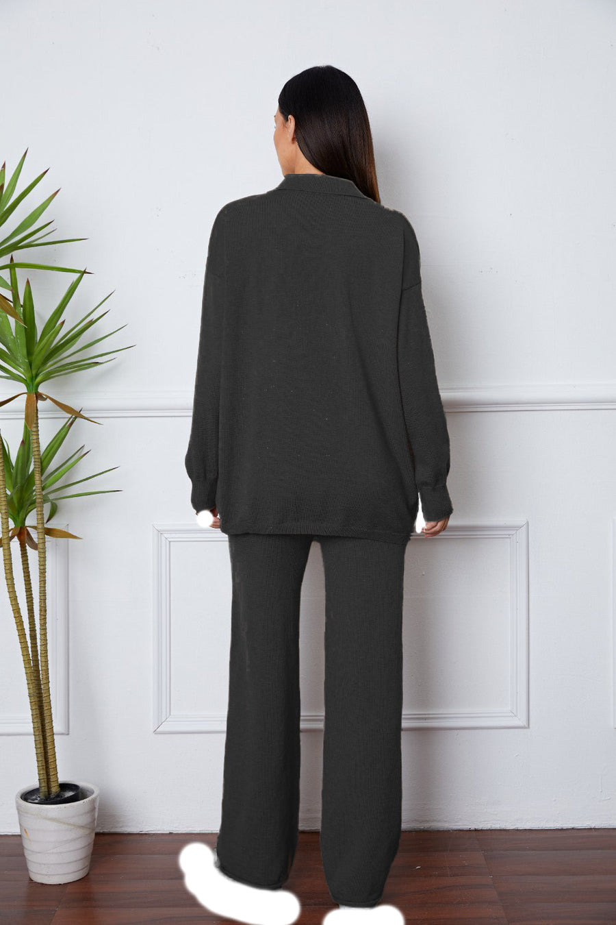Black relaxed knit polo co-ord set with wide leg pants and long sleeves.