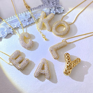 Puffed initial necklaces with zirconia and delicate gold chains, featuring letters C, K, O, L, E, A, Y.