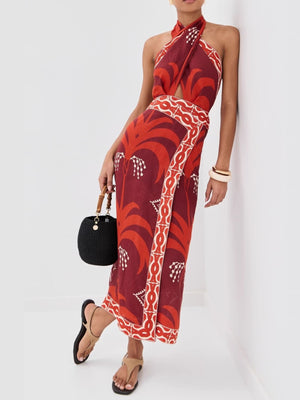 Tropical print halter neck dress with cutout and wrap skirt in red and orange.