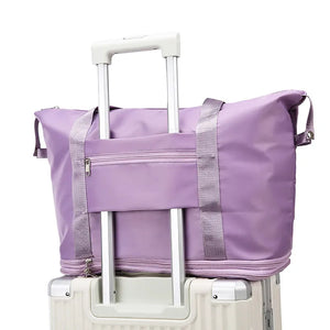 Expandable travel tote bag in lavender with contrast trim and zippered front pocket.