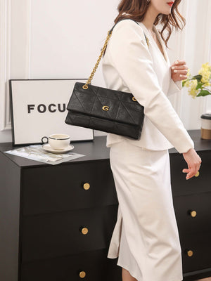 Black shoulder bag featuring quilted and geometric