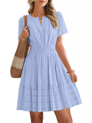 Light blue textured V-neck tiered dress with smocked waist and short sleeves.