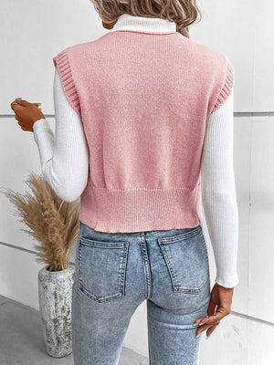 Dusty pink knit vest with ribbed trim and crew neck, worn over a white turtleneck.