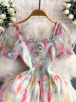 Floral tiered midi dress with smocked bodice, square neck, puff sleeves, and rosette detail.