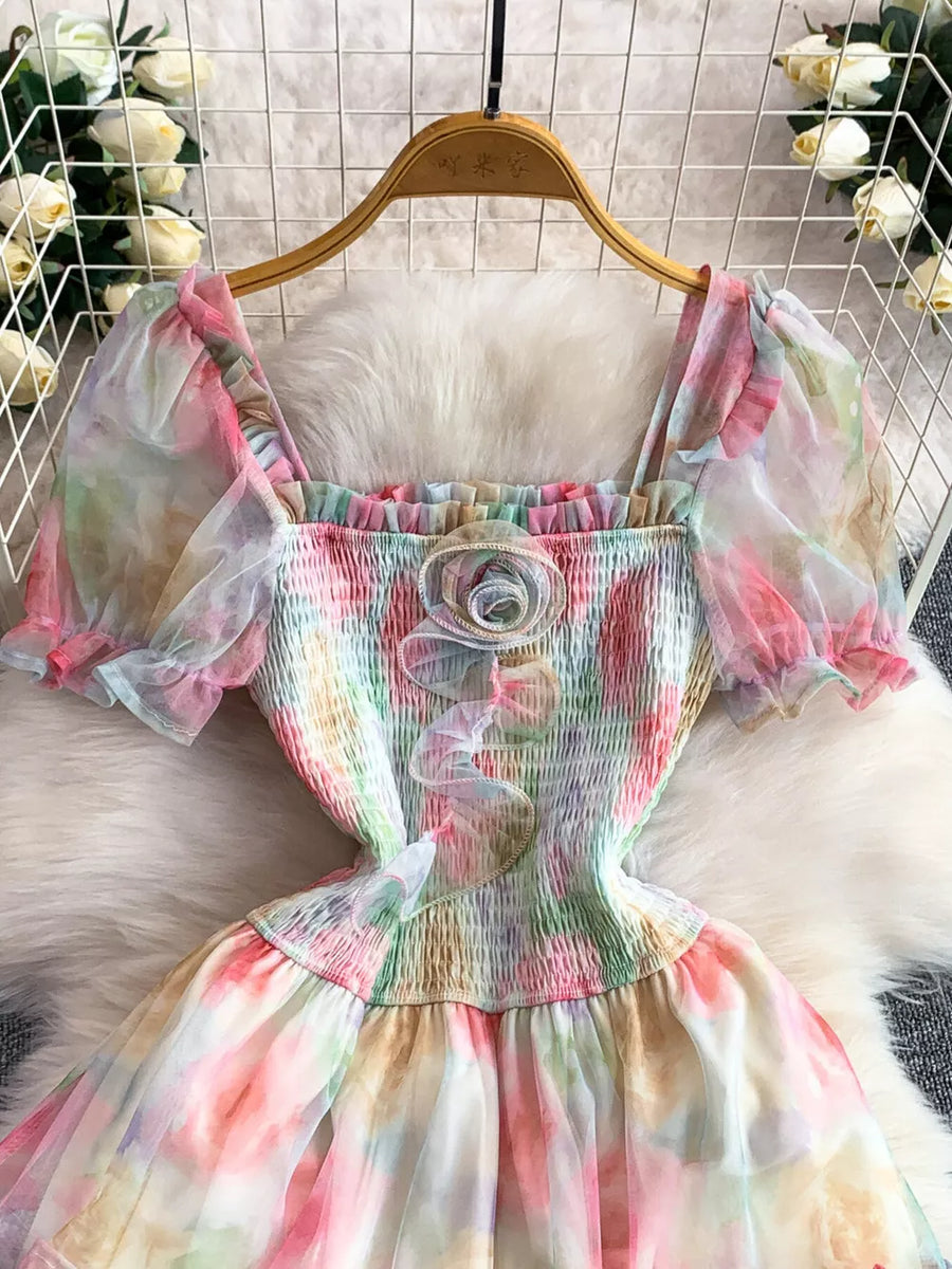 Floral tiered midi dress with smocked bodice, square neck, puff sleeves, and rosette detail.