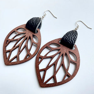 Brown wood leaf cutout dangle earrings with black leather accent.