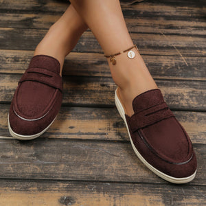 Textured brown slip-on loafers with a backless design and silver trim detail.