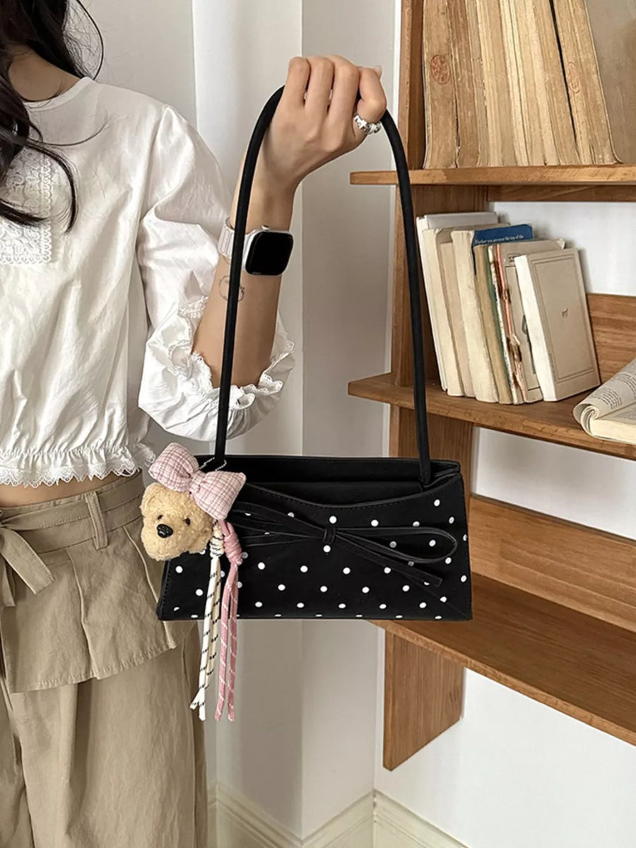 Black shoulder bag featuring bowknot decor and polka dot