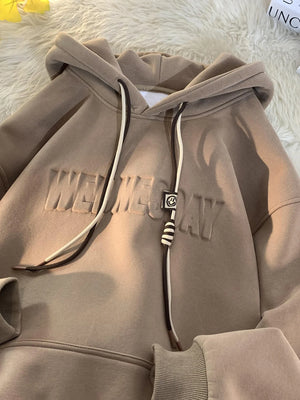 Tan cotton blend hoodie with embossed text and drawstring detail.