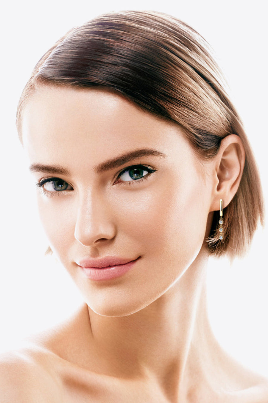Gold 18K gold-plated dangling gemstone sterling hoop earrings with three small clear gems.