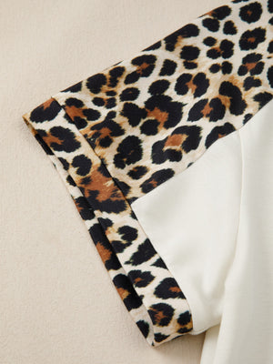 Leopard print buttoned blouse with beige contrast sleeves.