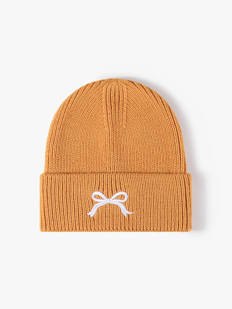 Tangerine ribbed knit beanie with embroidered white bow detail