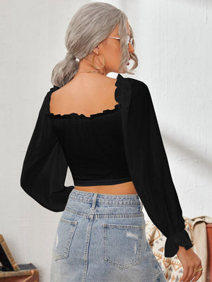 Black bustier blouse with square neckline, ruffled trim, and balloon sleeves.