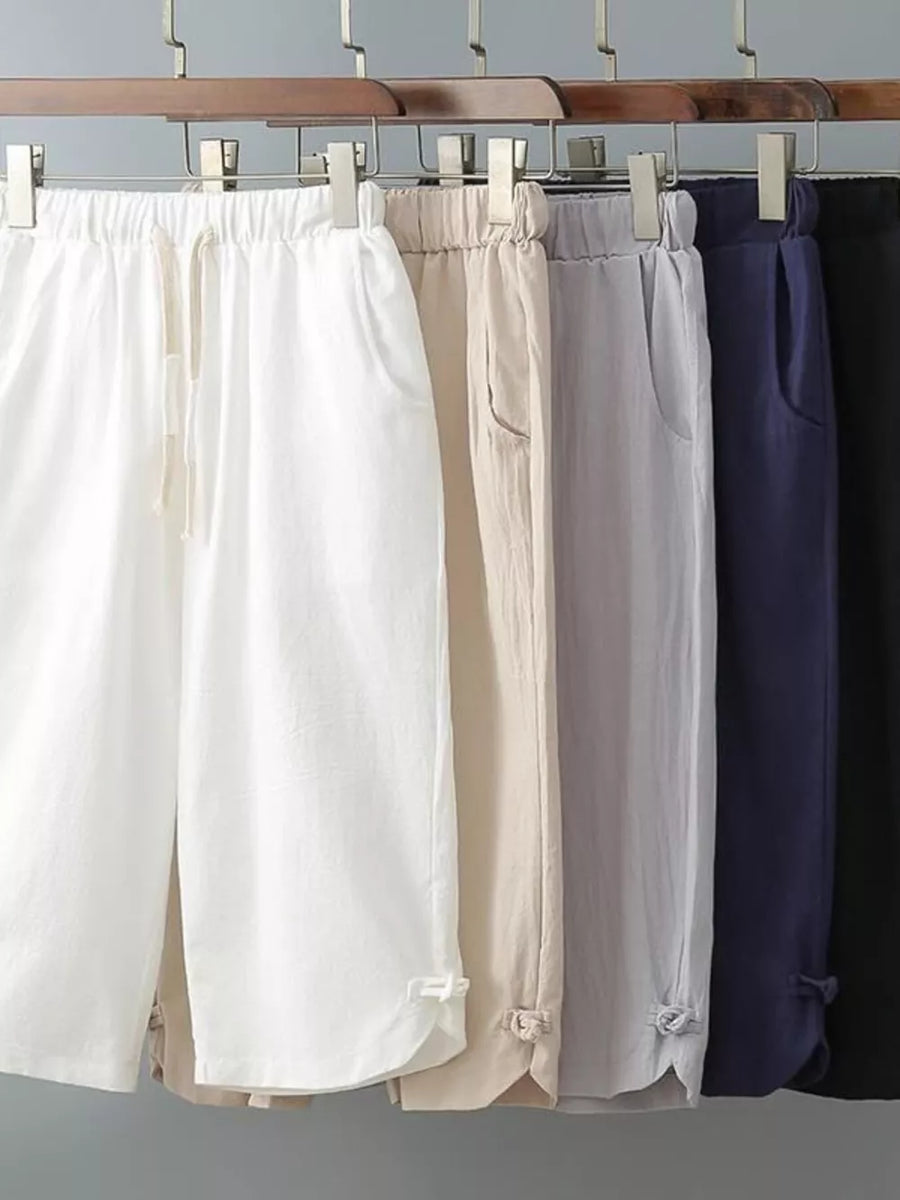 Men's cropped sweatpants in white, khaki, grey, navy blue, and black with drawstring waist and cuffed hems.