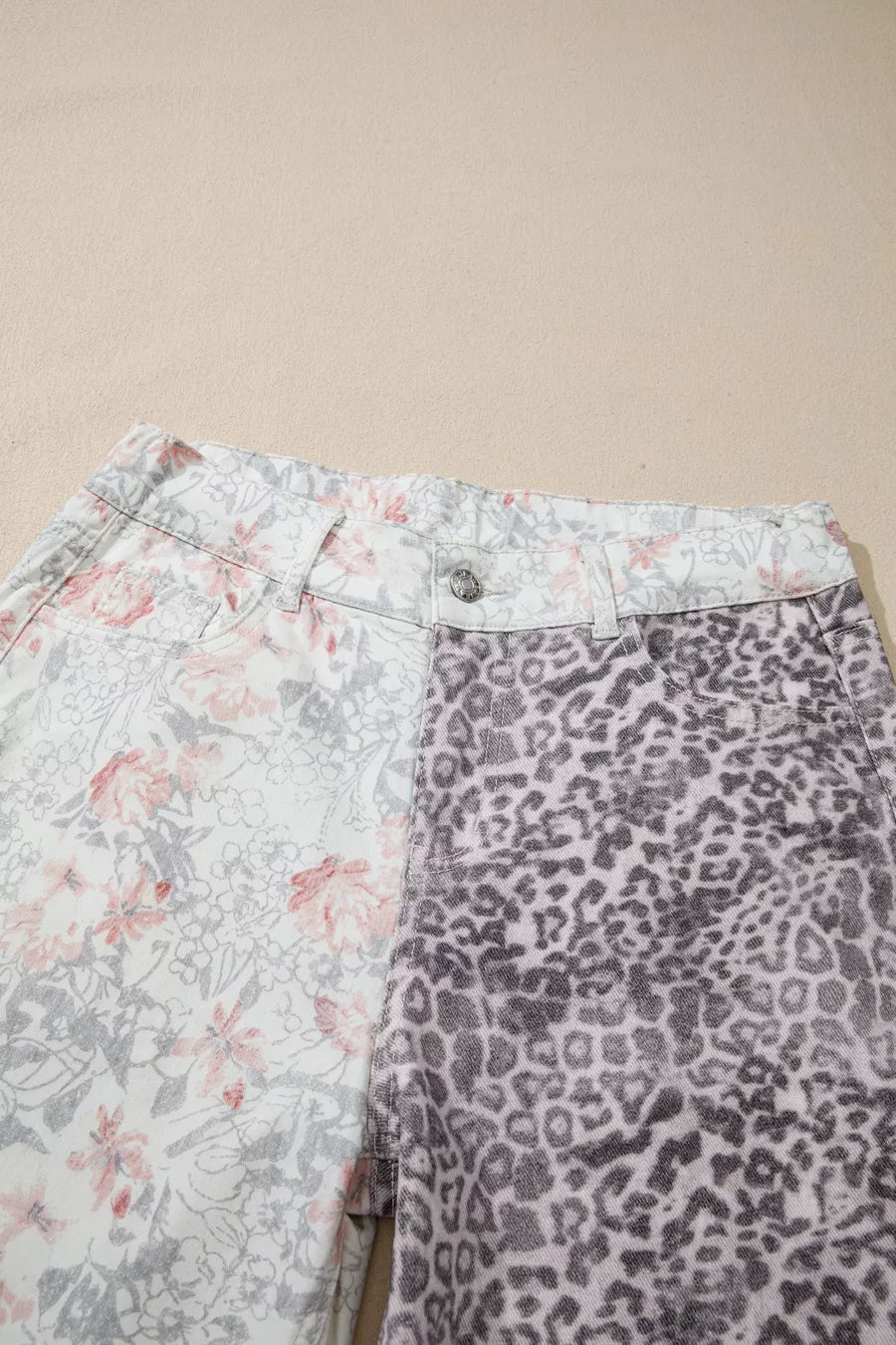 Floral and leopard print wide-leg jeans with a high waist and button closure.