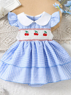 Baby dress in pastel blue gingham with smocked bodice and cherry embroidery.