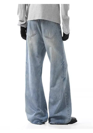 Men's light wash wide-leg jeans with button closure and distressed details.