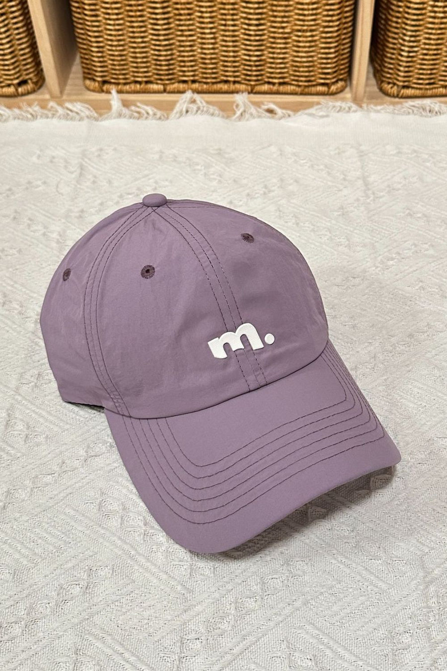 Purple baseball cap with white embroidered m.