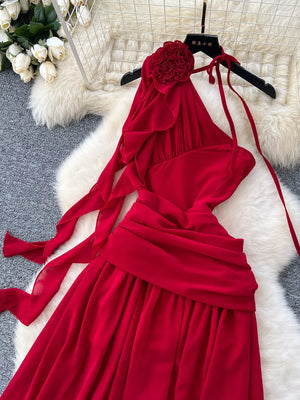 Red floral accent one-shoulder maxi dress with ruffled neckline and tie straps.
