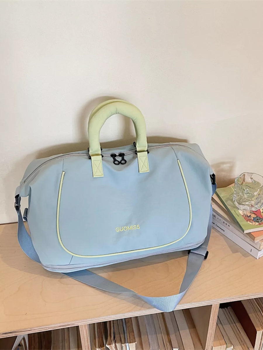 Light blue Oxford cloth duffle bag with chartreuse handles and trim, and a detachable shoulder strap.