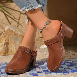 Brown round toe platform slip-ons with buckle detail and white stitching.