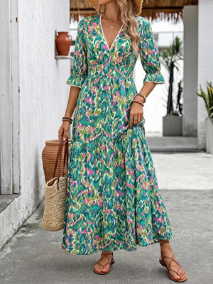 Vibrant V-neck flounce sleeve maxi dress with abstract print and tiered skirt.