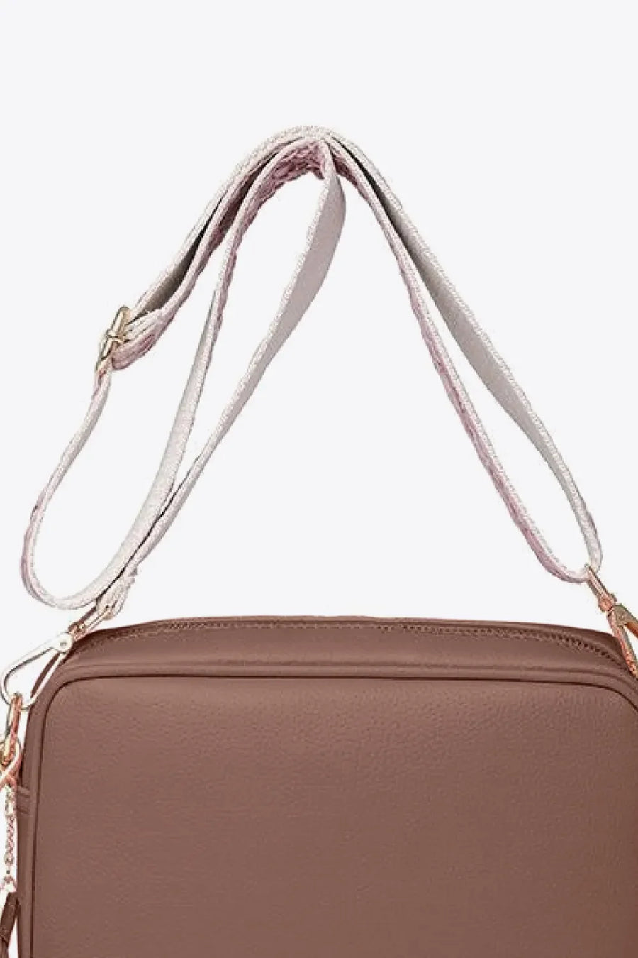Textured crossbody bag in brown with a patterned strap and tassel detail.