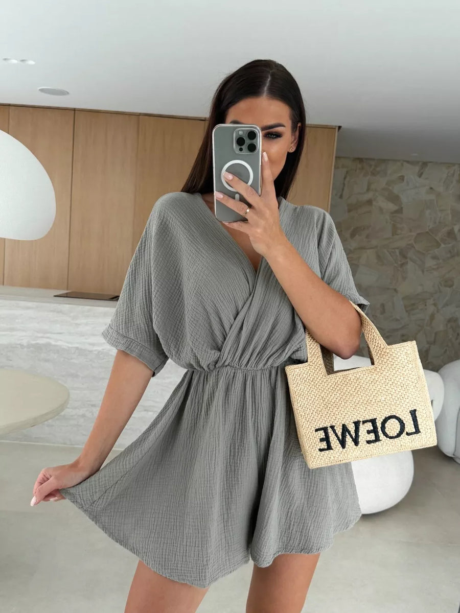 Dark gray twist-detail V-neck romper with cinched waist and dolman sleeves.