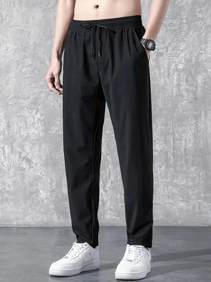 Black relaxed-fit drawstring trousers with elastic waistband and side pockets.