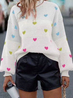 White knit sweater with colorful heart pattern, crew neck, and balloon sleeves.