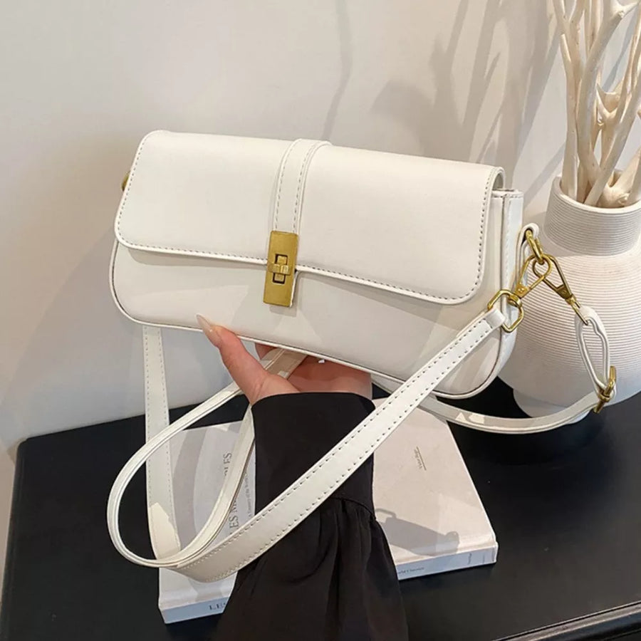 White rectangular crossbody bag with gold clasp and adjustable strap.