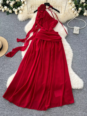 Red floral accent one-shoulder maxi dress with flowing skirt and tie details.