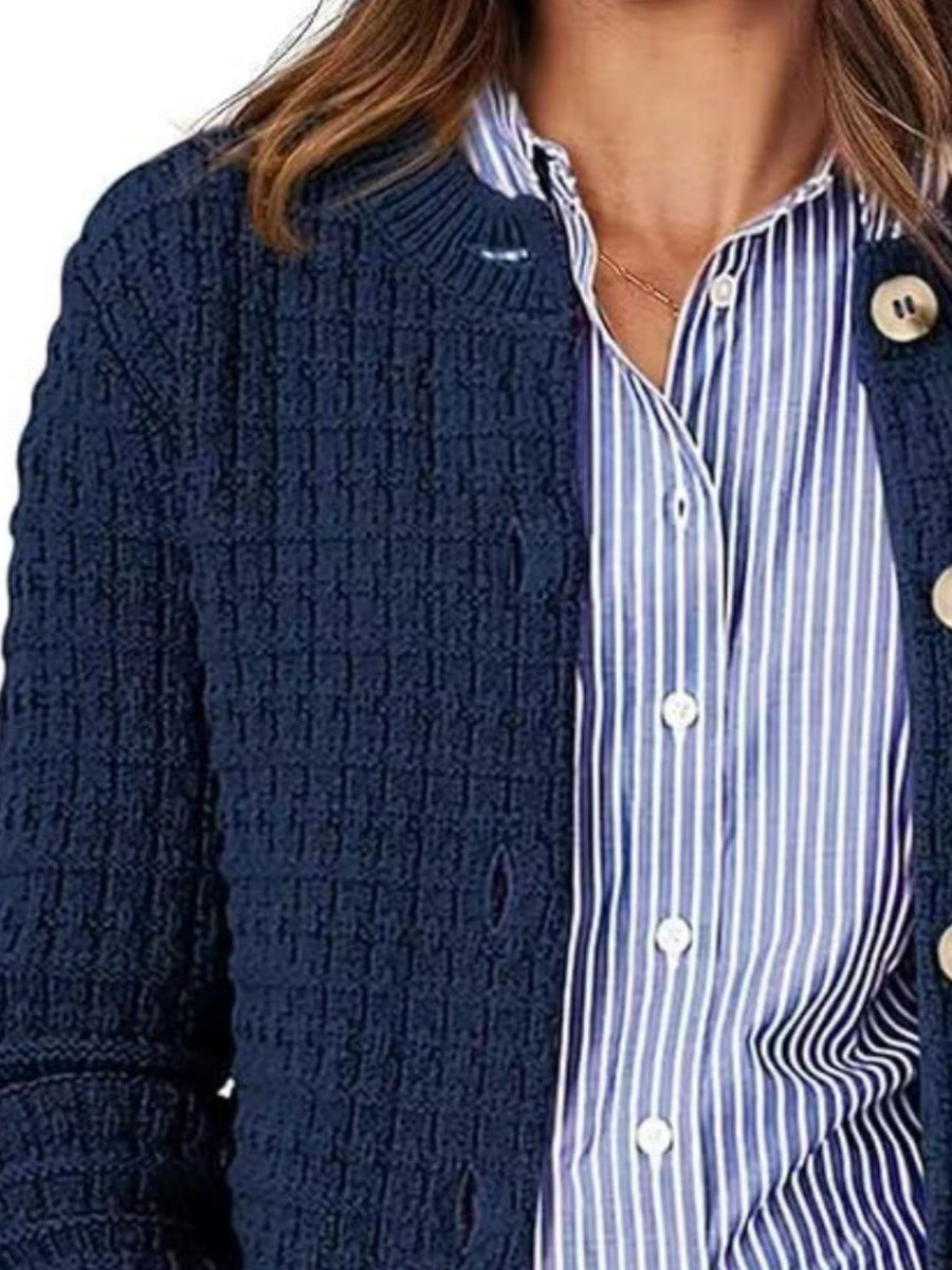 Navy textured knit button-up cardigan with cream buttons, styled over a blue striped shirt.