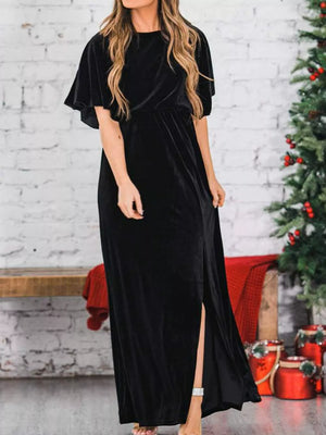 Black velvet maxi dress with flutter sleeves, cinched waist, and high slit.
