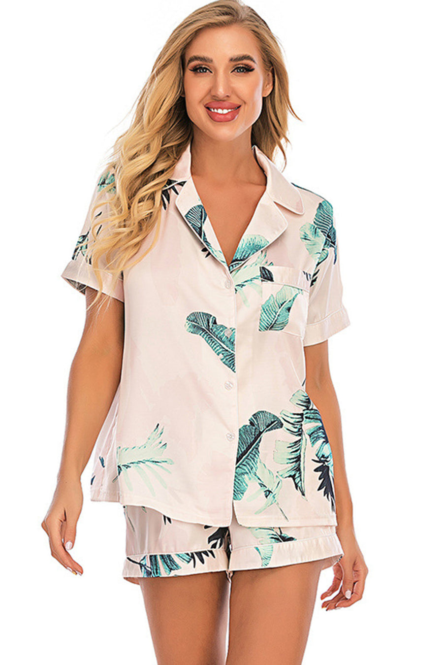 Blush pink botanical print satin pajama set with button-up top and shorts.