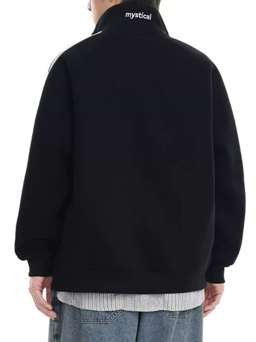 Black zip-up sweatshirt with white stripe detail on shoulder and "mystical" text on collar.