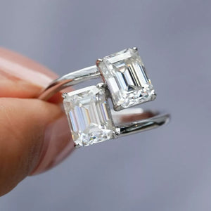 Emerald-cut moissanite bypass ring in silver with two large stones.