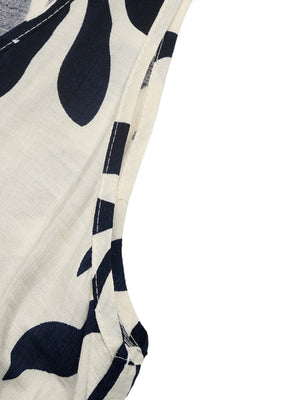 Belted dress with tropical leaf print, decorative buttons, and white trim detail.