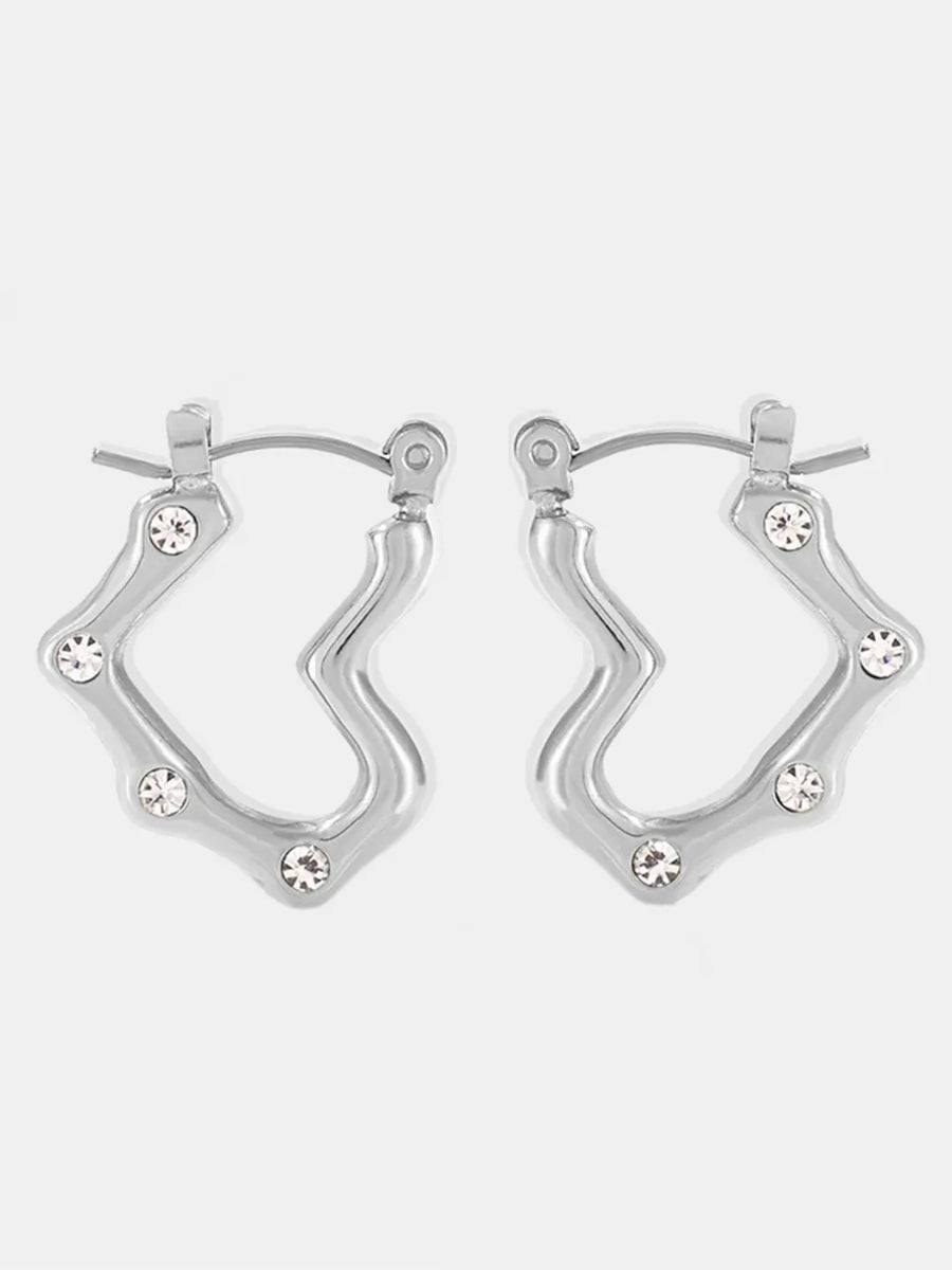 Sculpted wave hoop earrings in silver with clear bead accents.