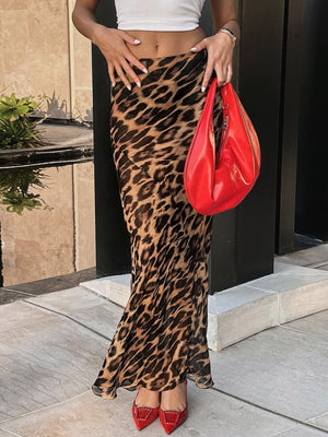 Print bodycon maxi skirt with leopard pattern, flowing fabric, and a high slit.